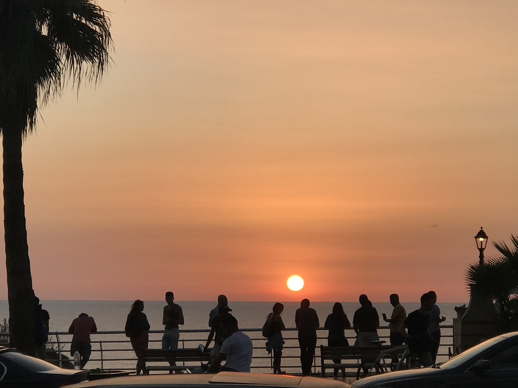 People watching the sun set over the ocean