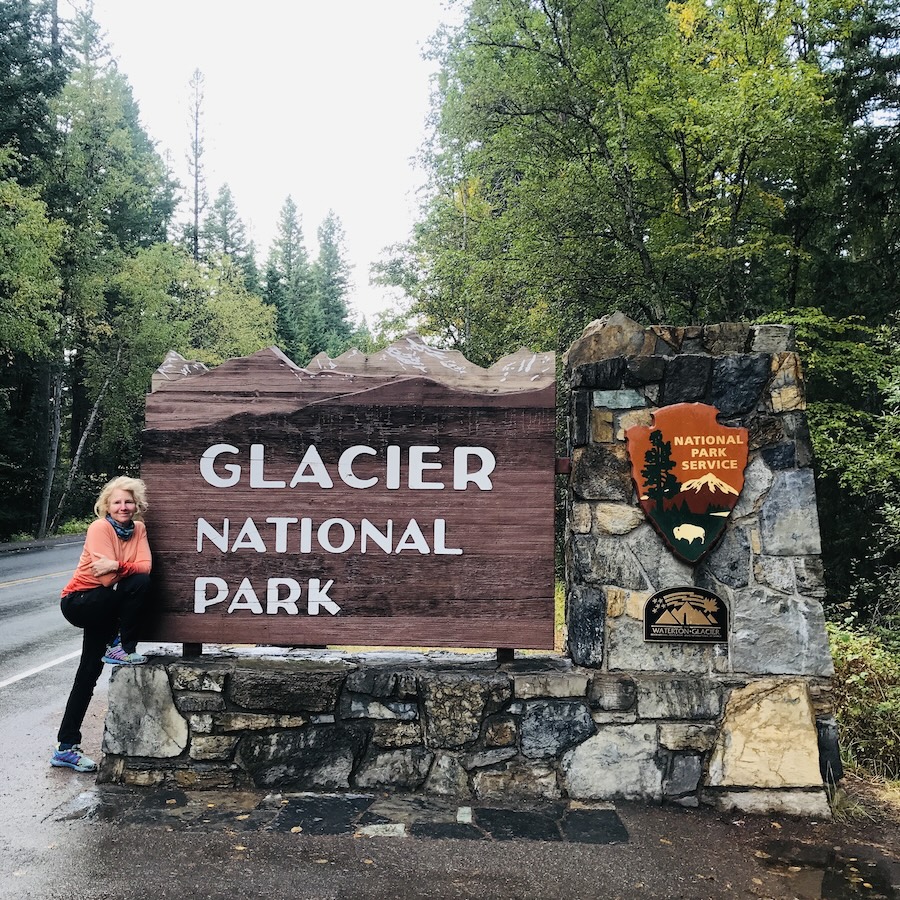 woman and Glacier National Park sign