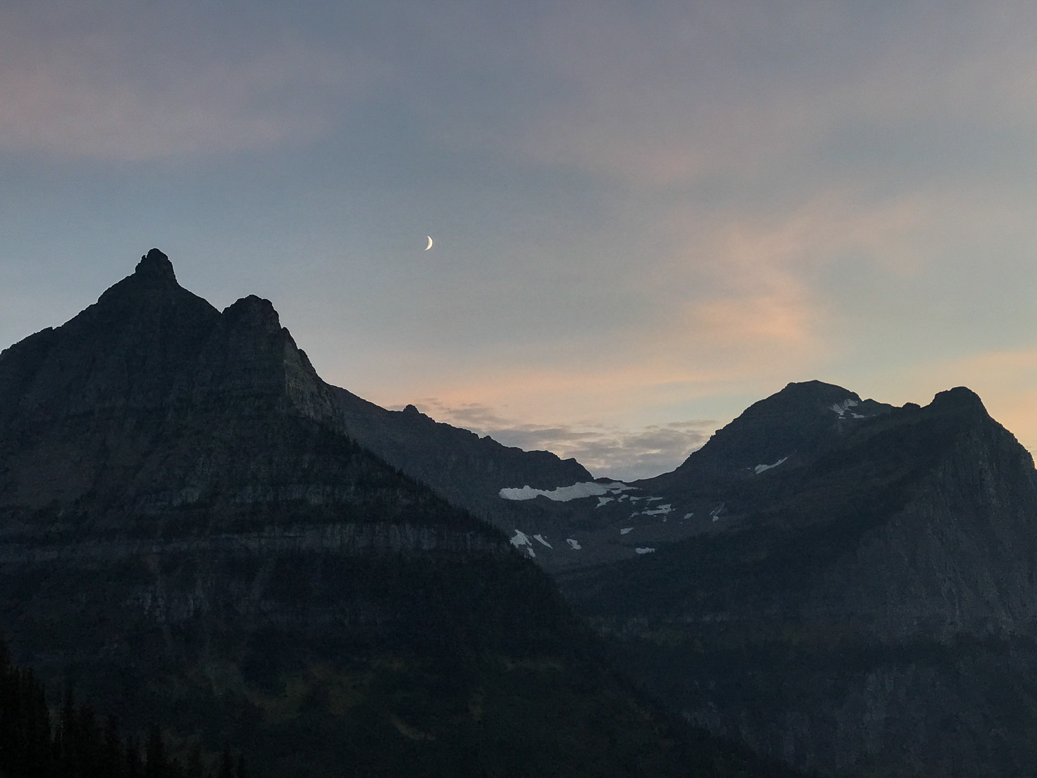 View of moon over majestic mountains from Highline Trail in Glacier National Park