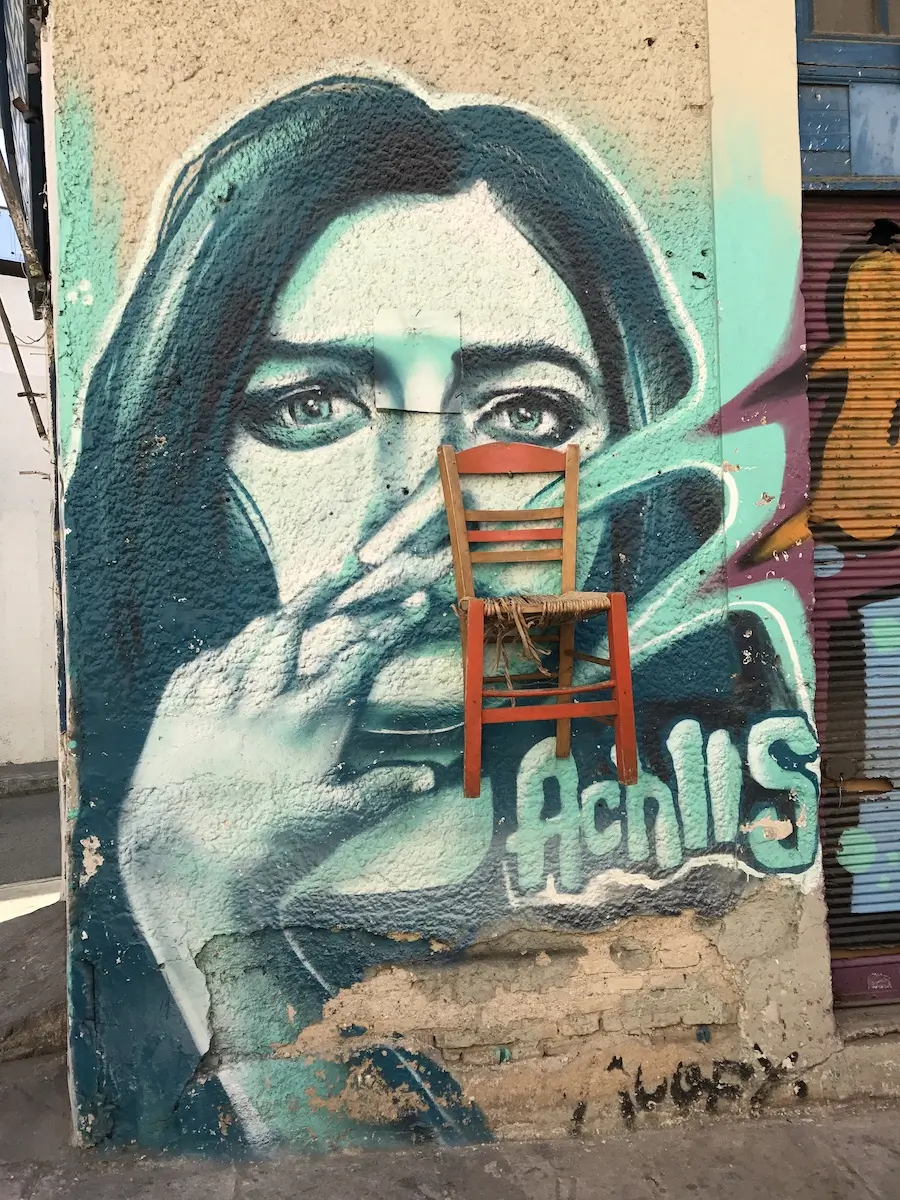 A painted face with a chair in Athens by Achillis