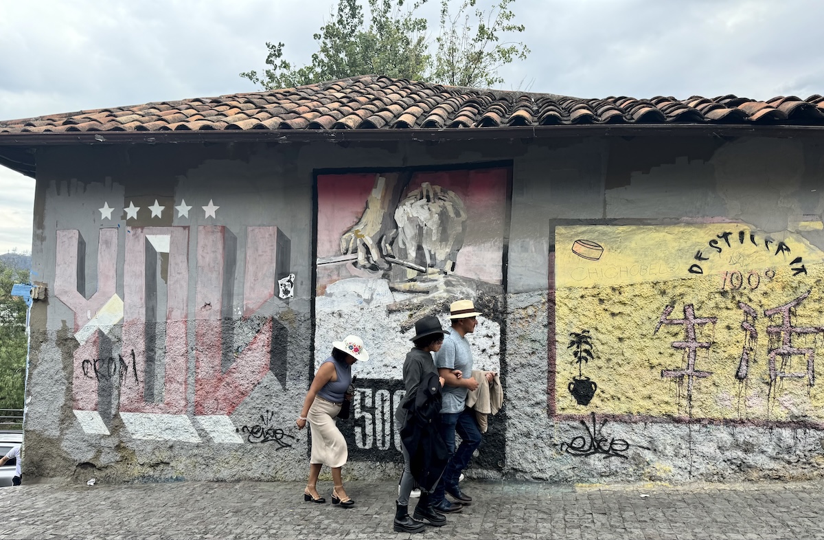 people walking in front of street art