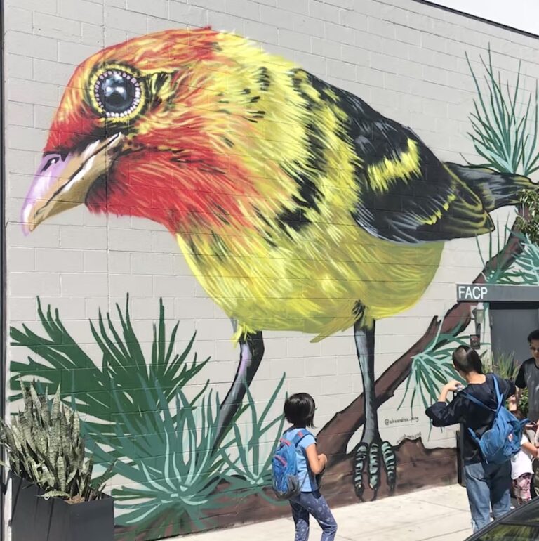 Large yellow and red mural of a bird by Alexandrea Pang at Crush in Denver