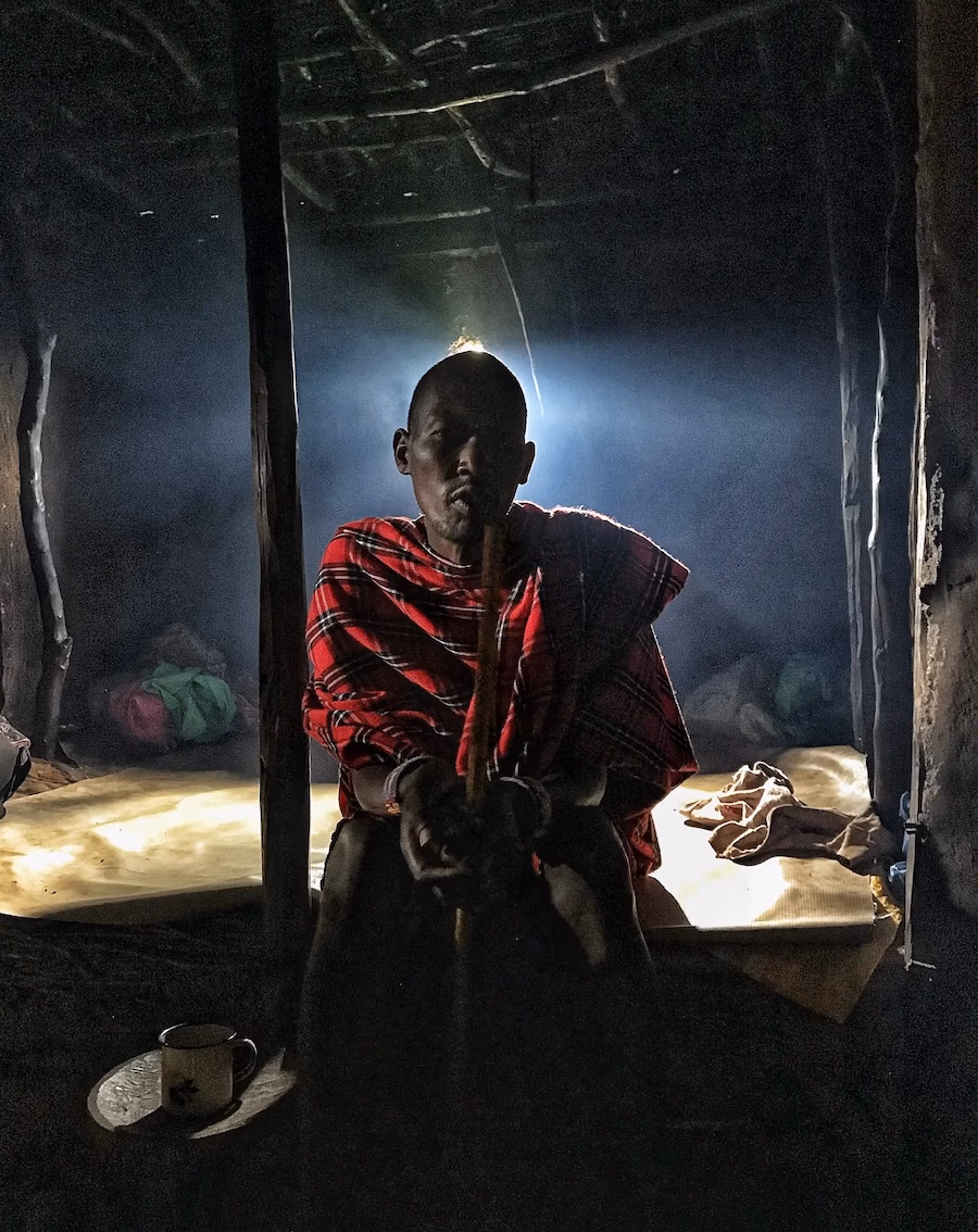 Maasai sitting on his bed in hut