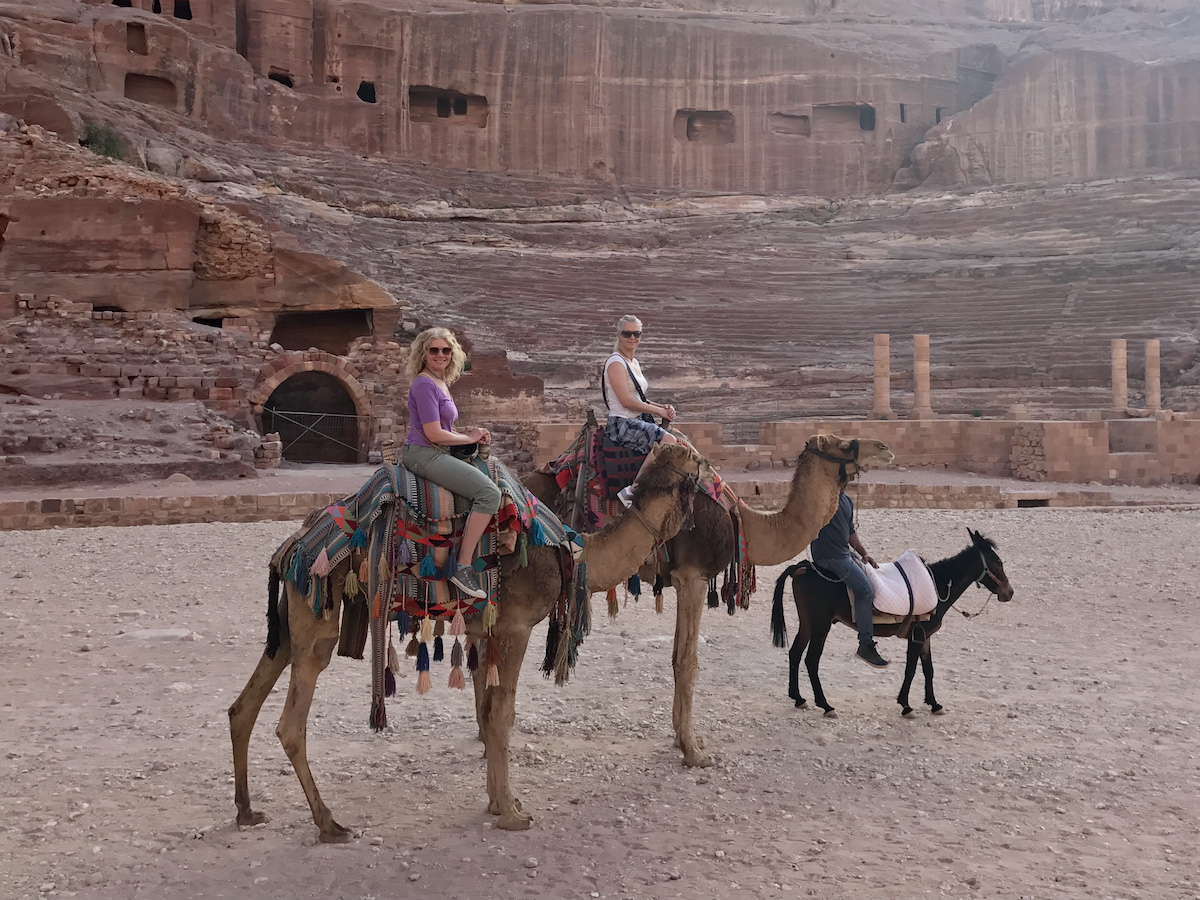 two women on camels with a donkey