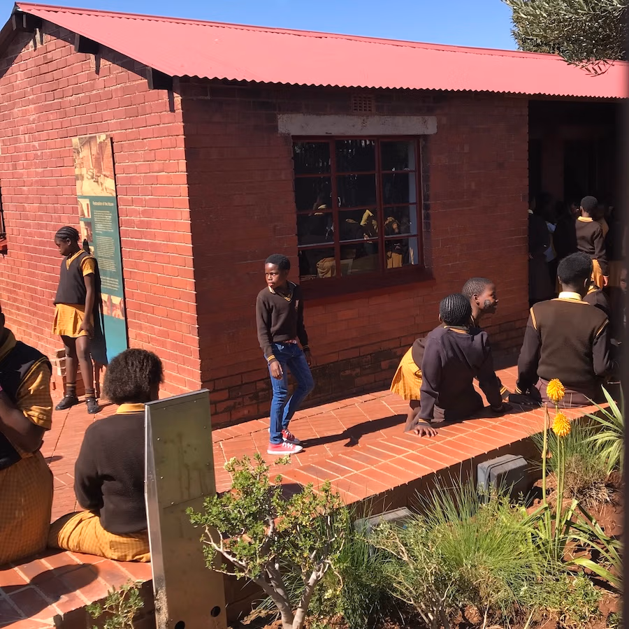 red brick house of Mandela with school kids