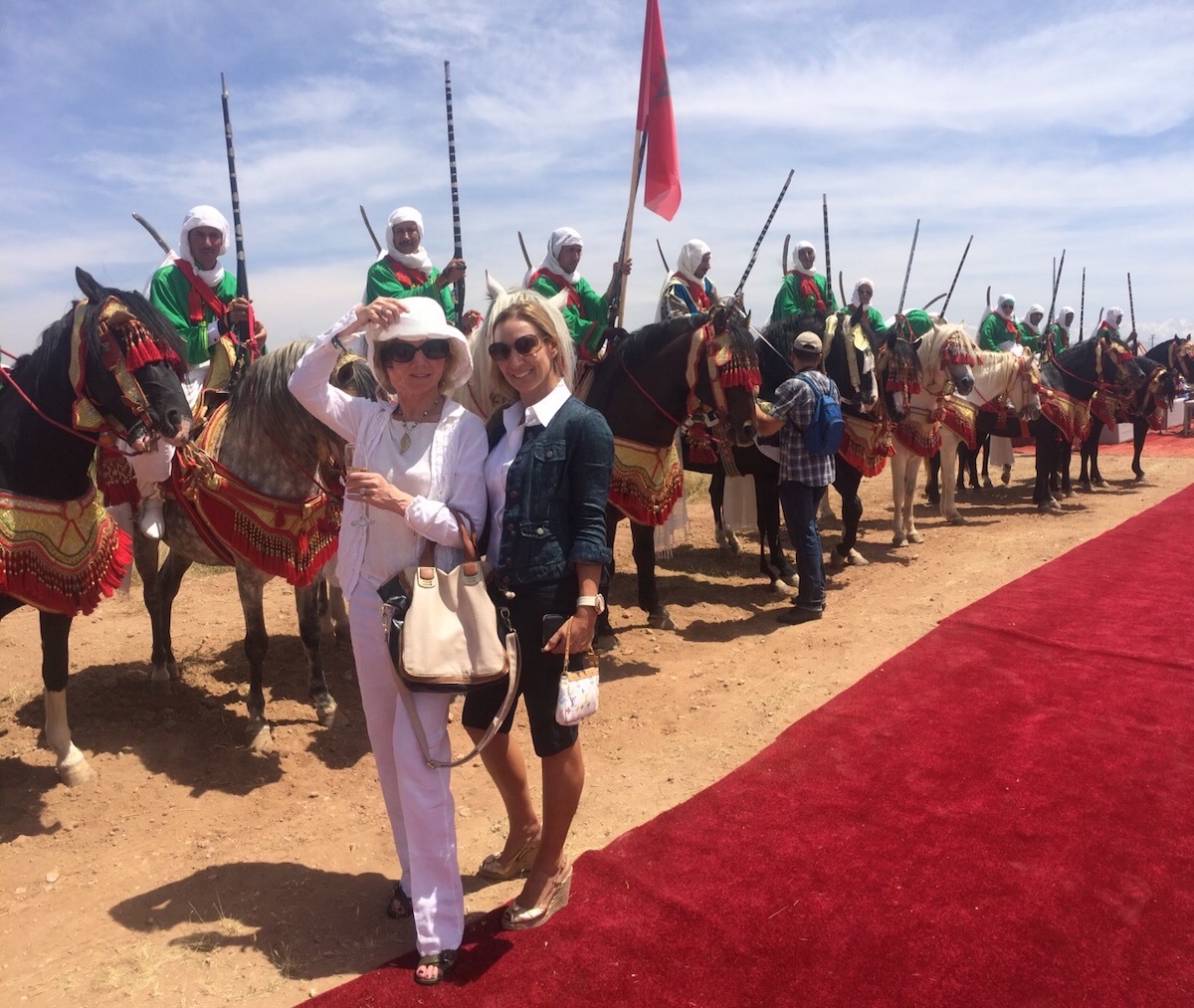 Morrocan polo players on horses two women standing in front