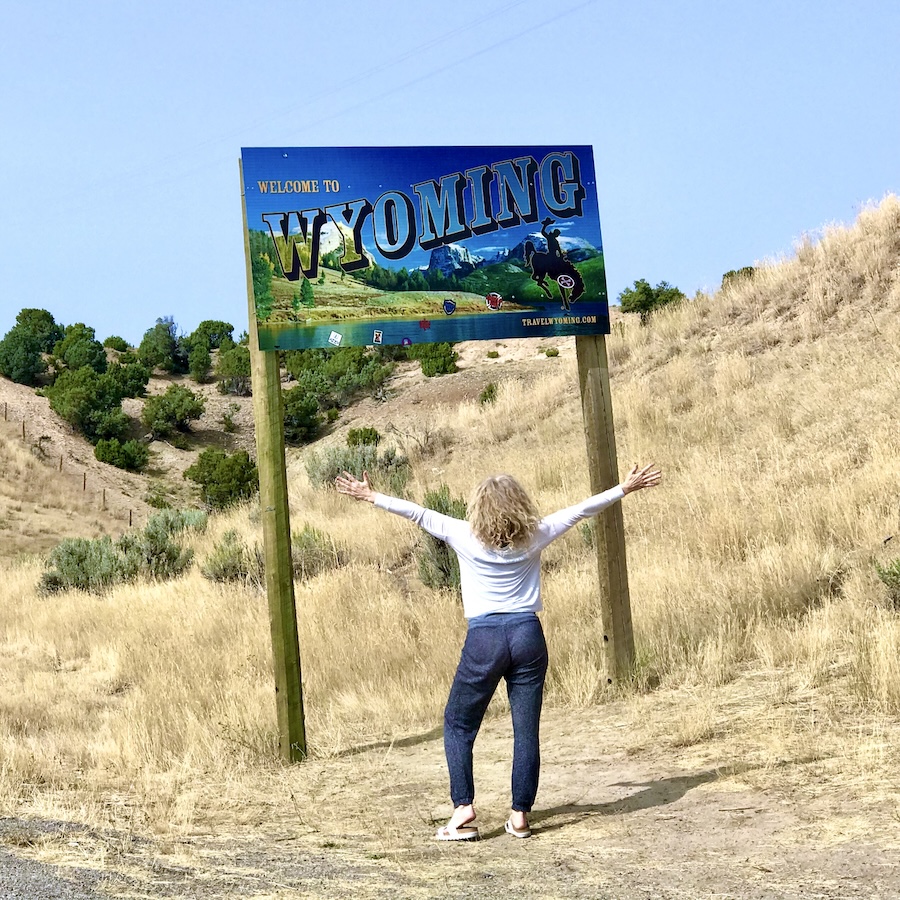 Woman looking at Wyoming sign