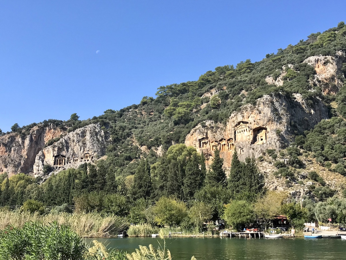 Tombs of Kaunos imbeded into green mountains with river in foreground