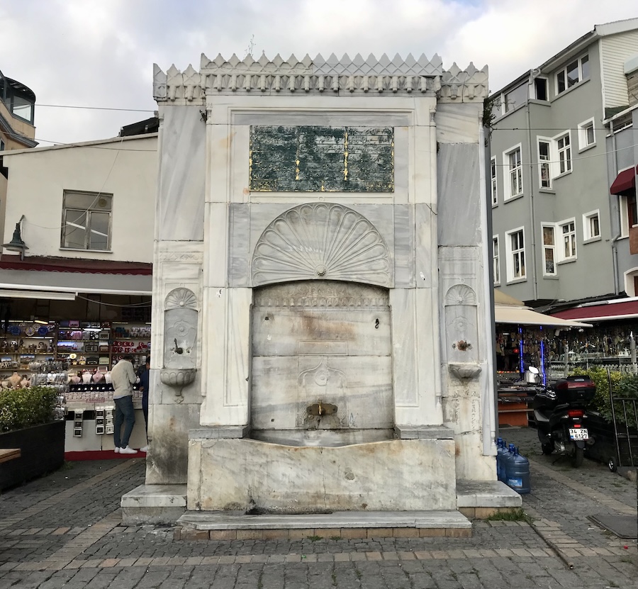A marble fountain sits in a commercial courtyard in Istanbul