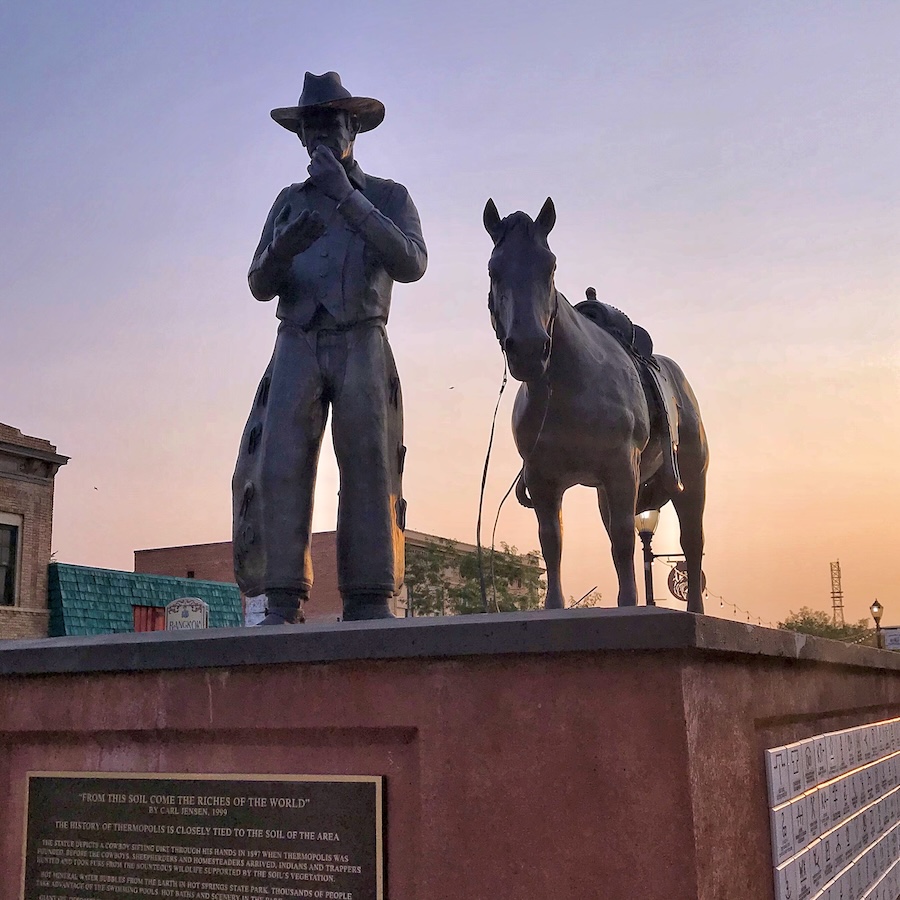 Statue of cowboy and horse at sunset