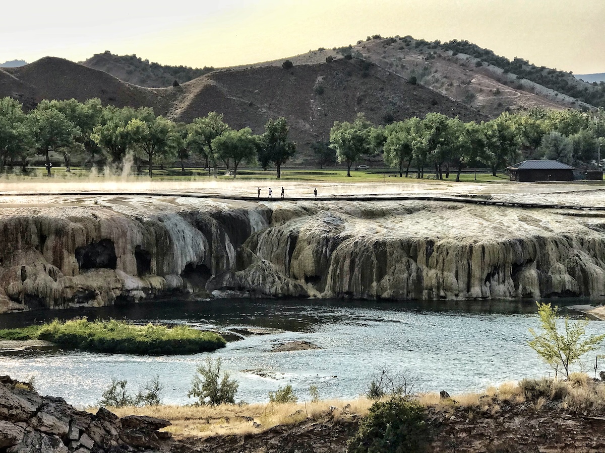 Mountains and trees with mineral rock formations and river in forground