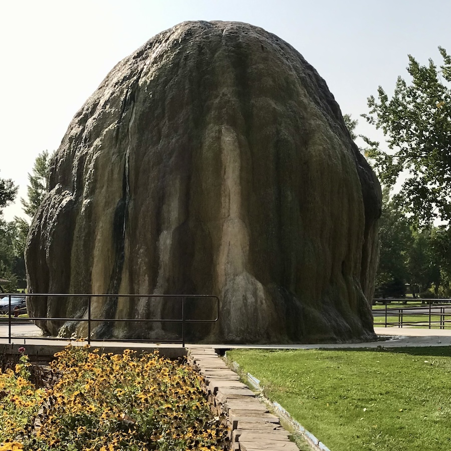 Large mineral rock formation with flowers