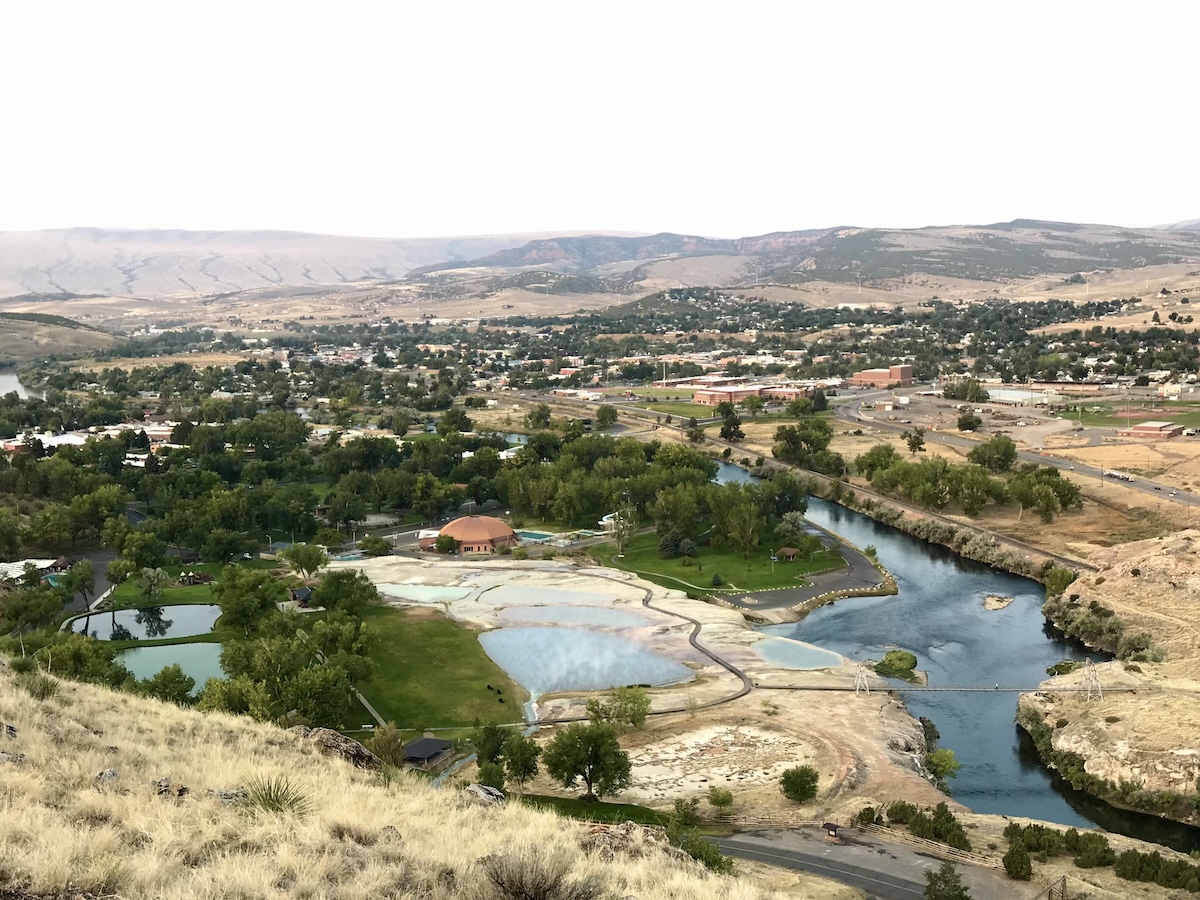 Scenic view of river, hot springs, trees and mountains