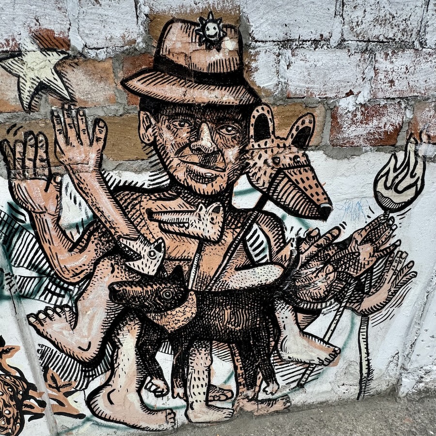 Street art Cuenca of Man carrying animals