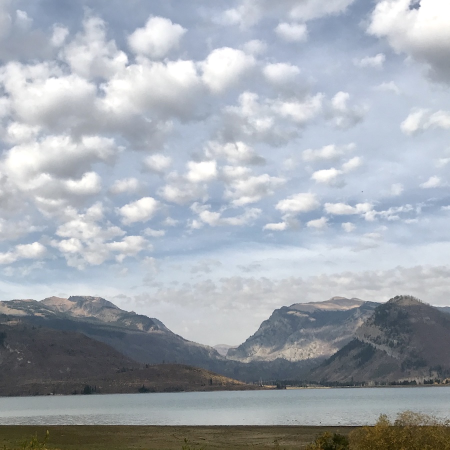 Cottonball clouds above mountains and a lake