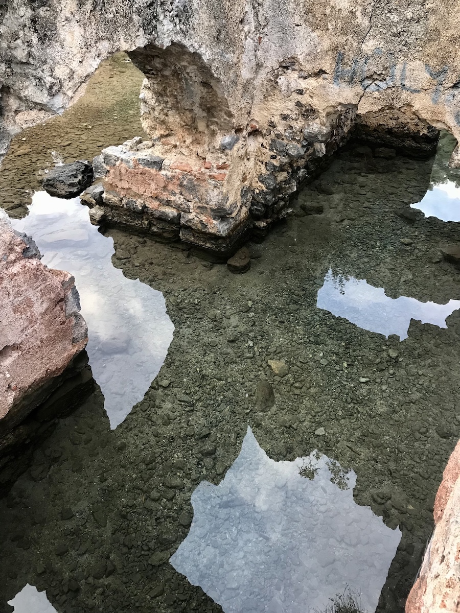 Abstract shot of rocky ruins and the geometric relection of its arches