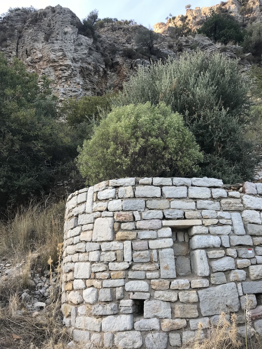 Ancient stone ruins of the Hellenistic amphitheater at the archaeological site of Amos, overlooking the Mediterranean Sea in Türkiye.