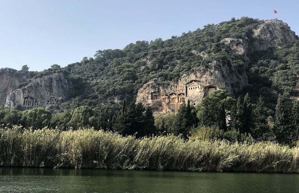 The rock tombs of Caunos appear on the green mountains above the waterway in Dalyan
