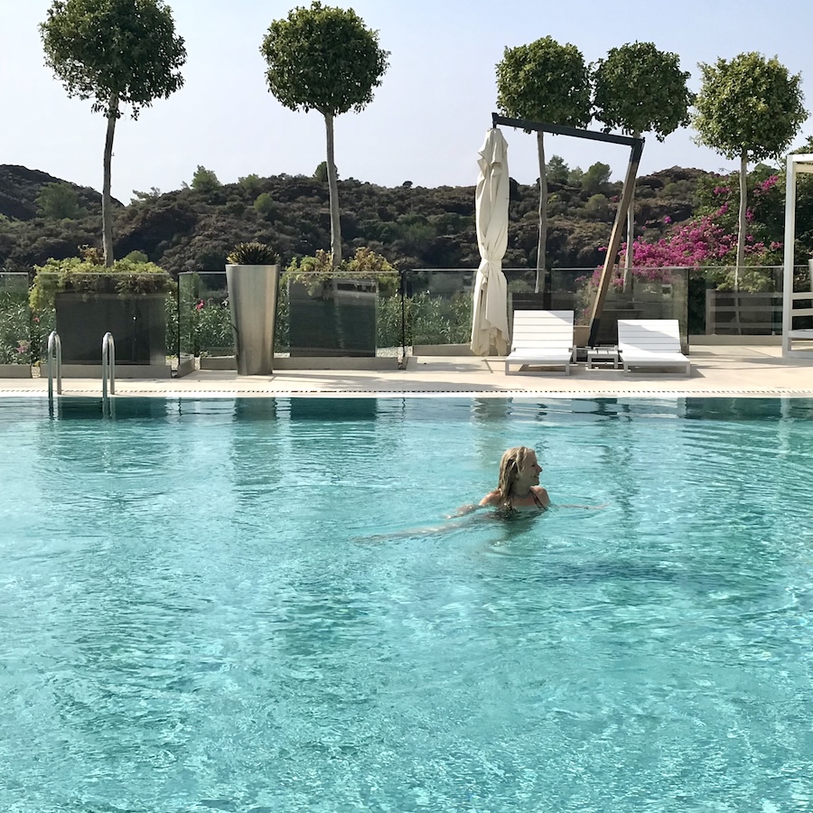 woman in pool with trees in background