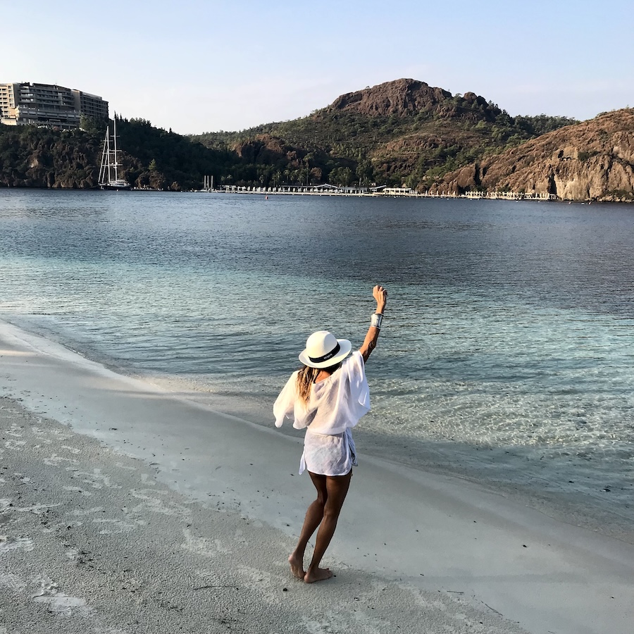 Woman standing on shore waving