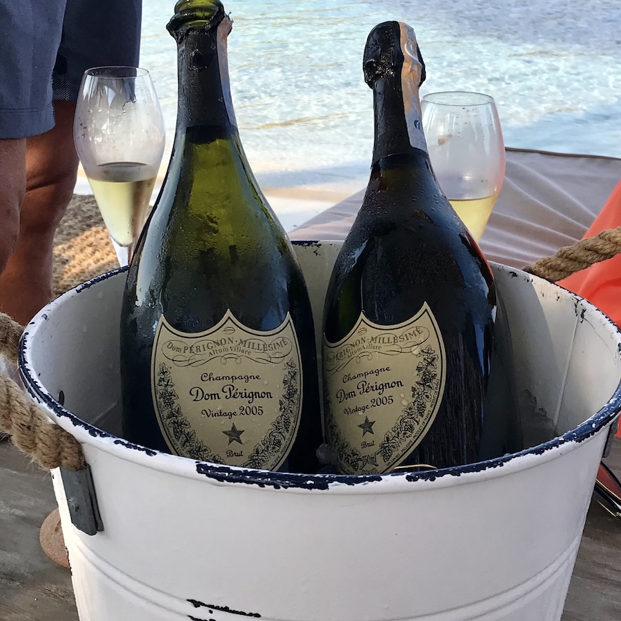 Two bottles of Dom Peringnon in a white bucket of ice
