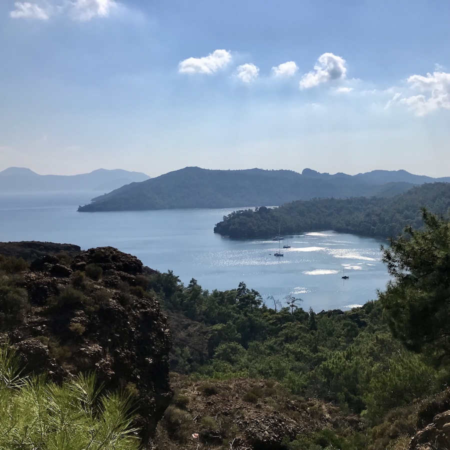 a mountain curves around with the ocean bay