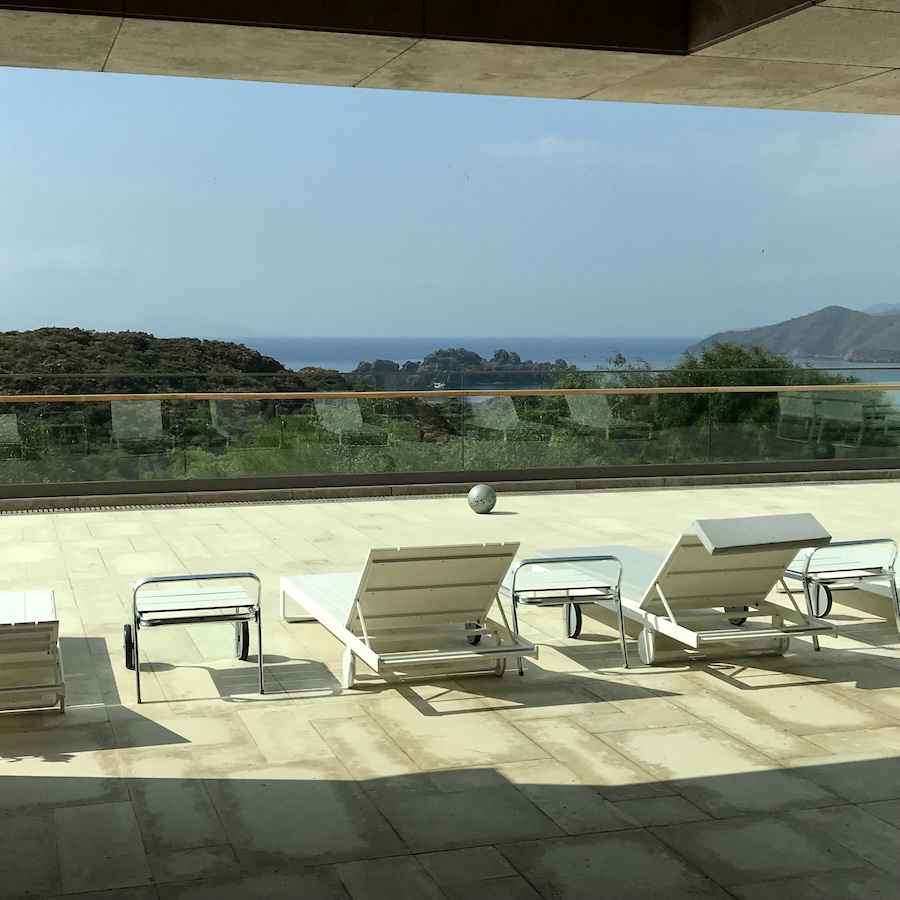 Lounge chairs on balcony overlooking the mountains and sea