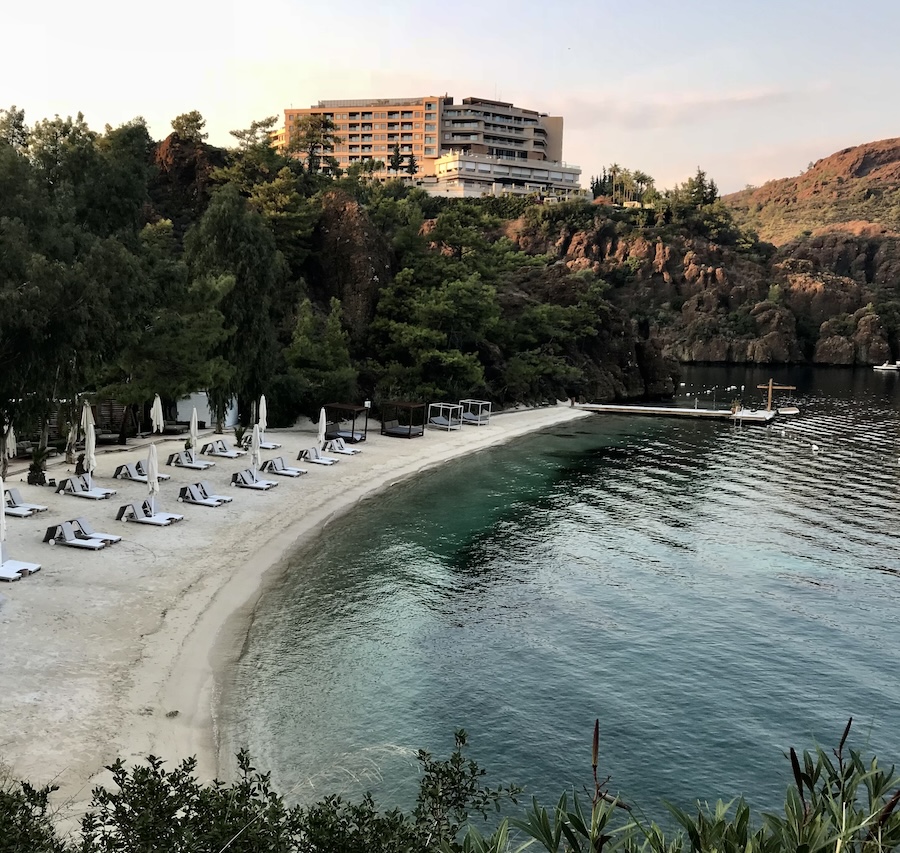 Beach chairs line the ocean cove at sunset