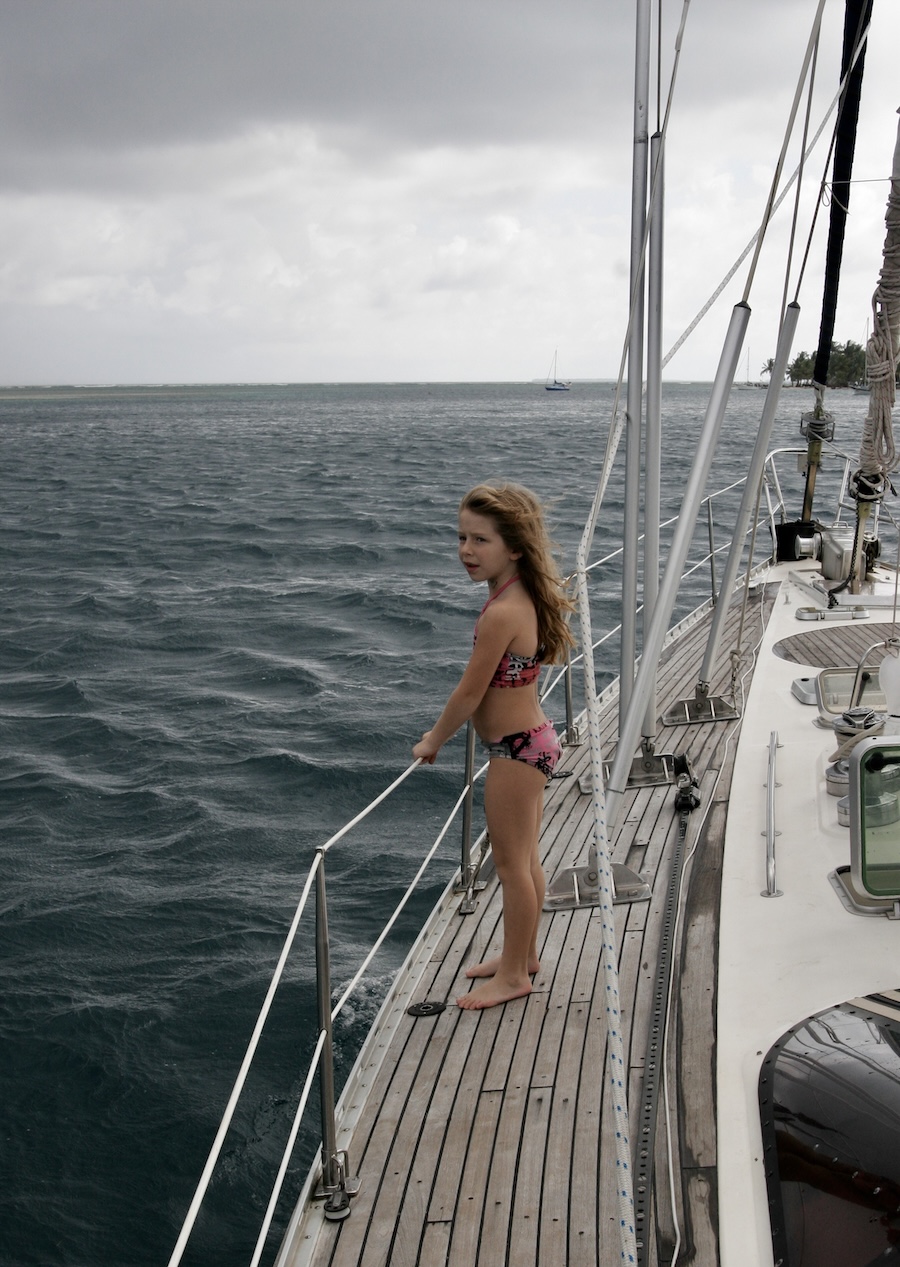 Girl standing on deck of a sailboat looking at the sea