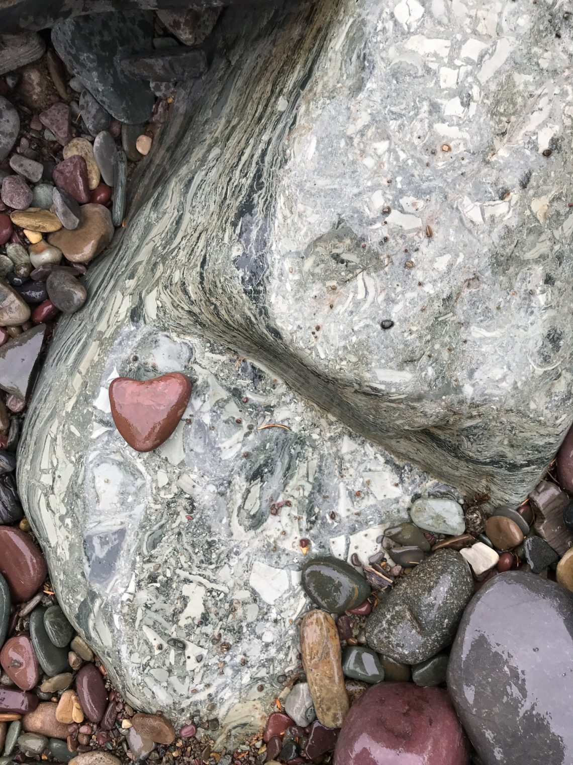 Rust colored heart shaped rock in a stream bed